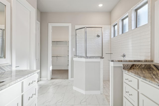 bathroom featuring a tile shower and vanity