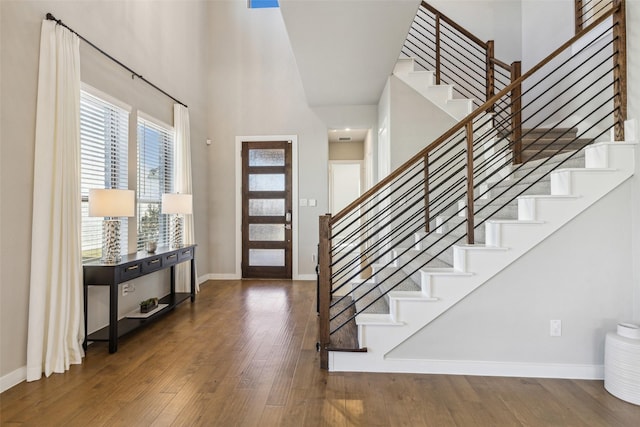 foyer entrance featuring dark hardwood / wood-style floors and a towering ceiling