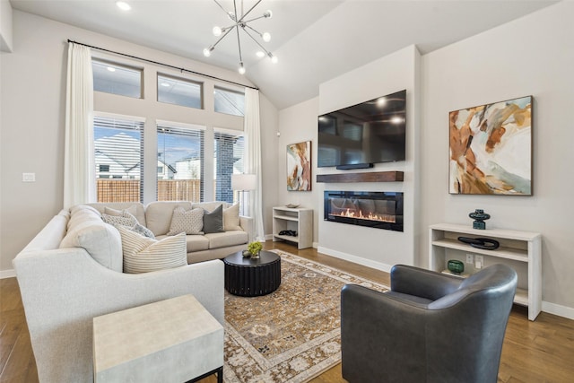 living room featuring hardwood / wood-style flooring, a notable chandelier, and vaulted ceiling