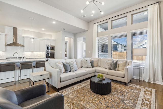 living room featuring dark hardwood / wood-style floors, sink, and a chandelier