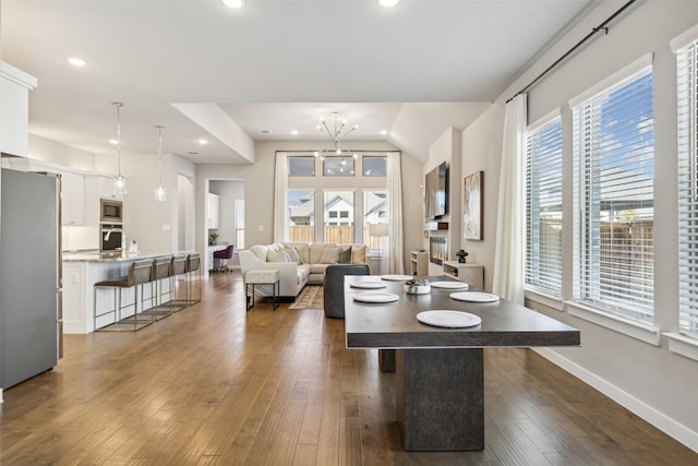 dining area featuring dark hardwood / wood-style flooring and an inviting chandelier