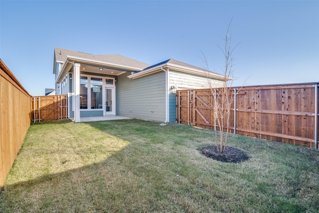 back of house featuring a lawn, a patio area, and french doors