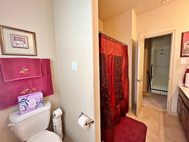 bathroom with tile patterned floors, vanity, toilet, and walk in shower