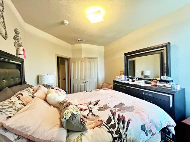 bedroom with a textured ceiling and a closet