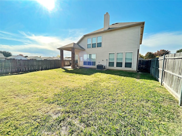 back of property featuring central AC unit and a yard