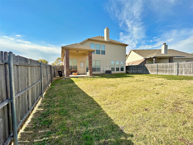 rear view of house with a yard and central AC unit