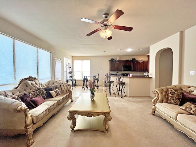 carpeted living room featuring ceiling fan