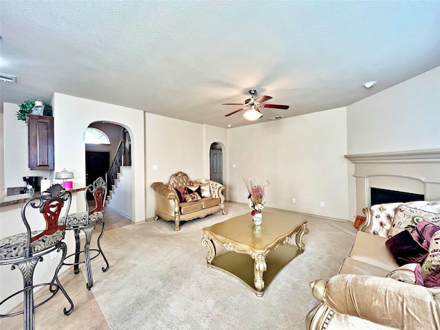 living room featuring ceiling fan and a textured ceiling