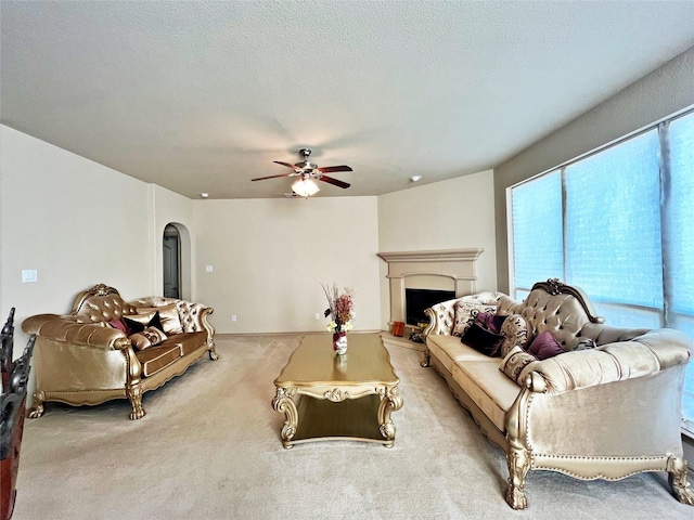 carpeted living room featuring ceiling fan and a textured ceiling