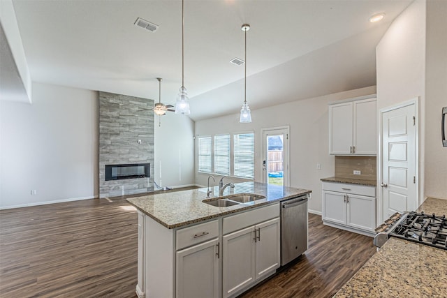 kitchen featuring pendant lighting, white cabinetry, sink, light stone counters, and stainless steel appliances