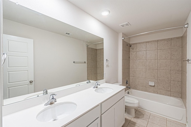 full bathroom featuring toilet, tile patterned flooring, vanity, and tiled shower / bath combo