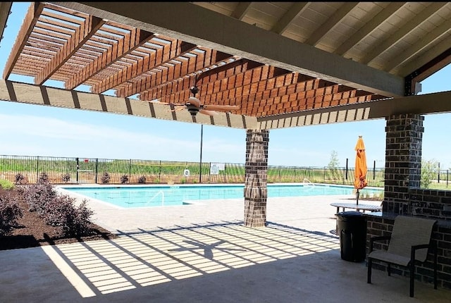 view of pool with ceiling fan, a pergola, and a patio area