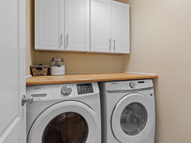 washroom with cabinets and washer and dryer