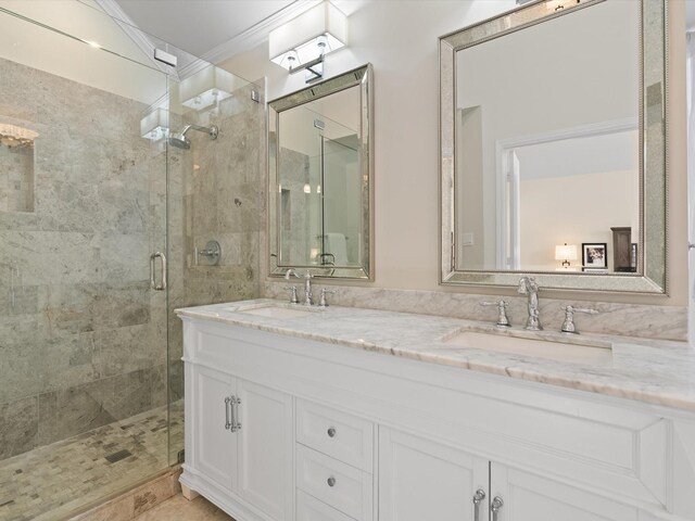 bathroom with crown molding, vanity, and a shower with shower door