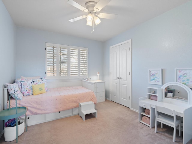 bedroom with a closet, ceiling fan, and light colored carpet