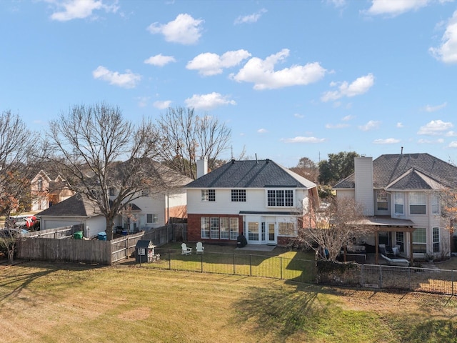 back of property with a lawn and french doors