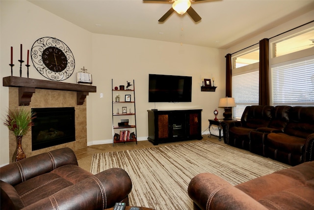 living room featuring a tile fireplace and ceiling fan