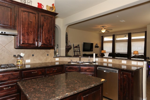 kitchen with sink, stainless steel appliances, range hood, and dark stone counters