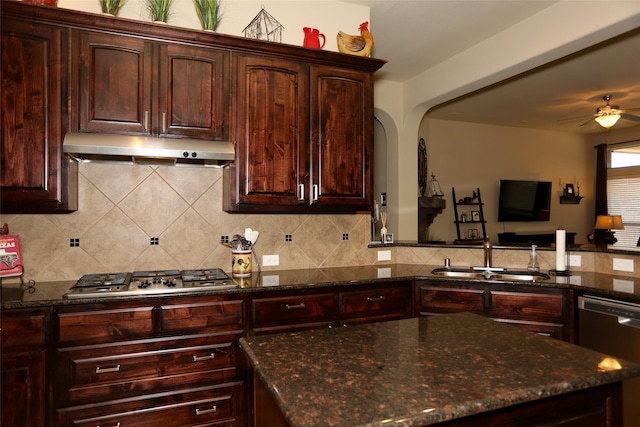 kitchen with backsplash, dark stone countertops, sink, and stainless steel appliances