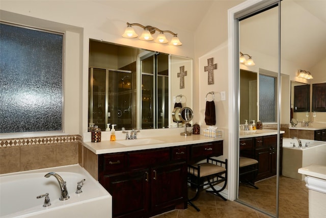 bathroom with tile patterned flooring, vanity, vaulted ceiling, and separate shower and tub