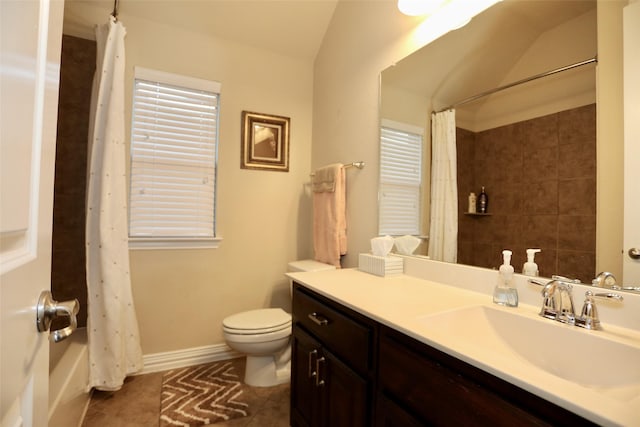 full bathroom featuring tile patterned floors, vanity, vaulted ceiling, shower / bath combo with shower curtain, and toilet