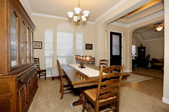 carpeted dining room featuring ceiling fan with notable chandelier and ornamental molding