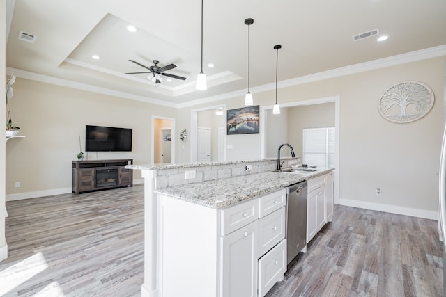 kitchen with a raised ceiling, white cabinetry, stainless steel dishwasher, and sink