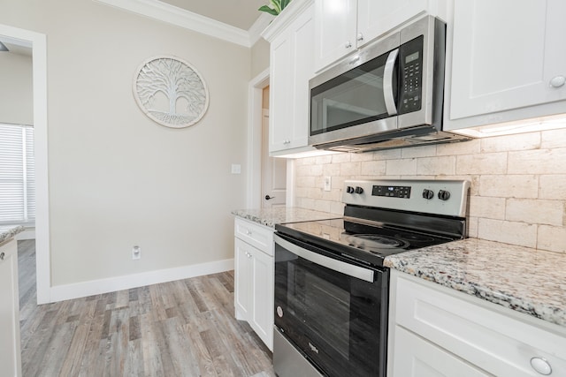 kitchen with white cabinets, crown molding, light hardwood / wood-style flooring, light stone countertops, and stainless steel appliances