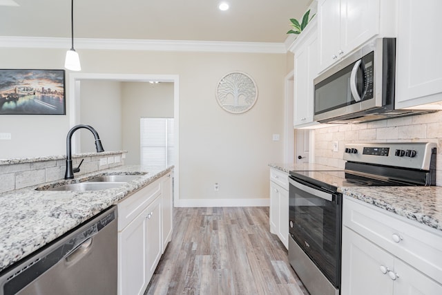 kitchen with pendant lighting, stainless steel appliances, white cabinetry, and sink