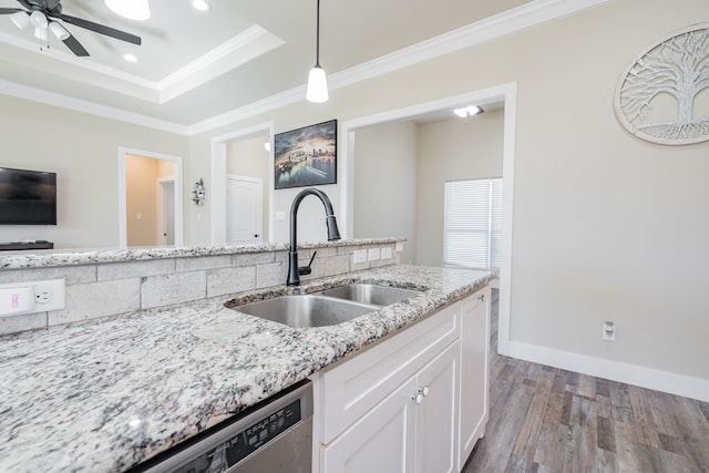 kitchen with white cabinetry, sink, light stone counters, crown molding, and pendant lighting