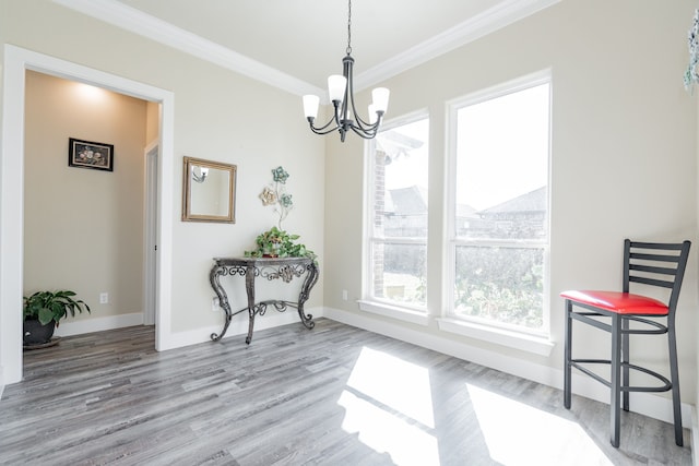 dining room with hardwood / wood-style floors, crown molding, and a chandelier