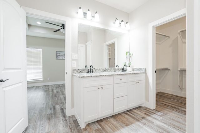 bathroom with hardwood / wood-style flooring, ceiling fan, and vanity