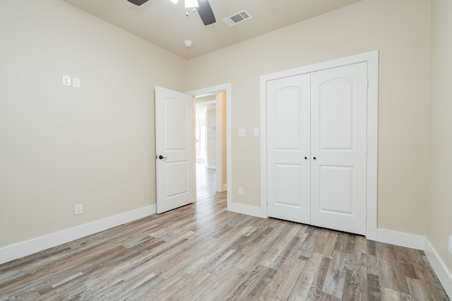 unfurnished bedroom with ceiling fan, a closet, and light hardwood / wood-style floors