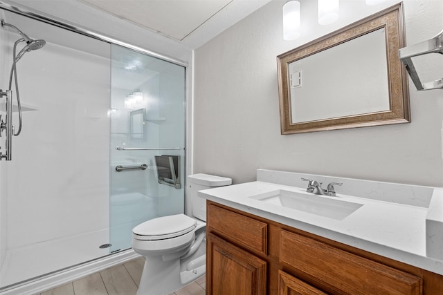 bathroom with vanity, toilet, and a shower with door