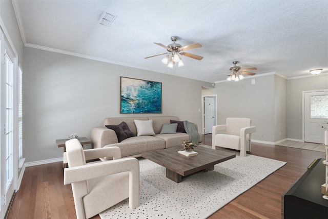 living room with dark hardwood / wood-style floors, ornamental molding, and a wealth of natural light