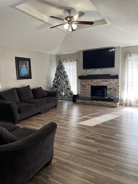 living room featuring a tray ceiling, ceiling fan, hardwood / wood-style flooring, a fireplace, and lofted ceiling