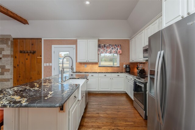 kitchen featuring a large island, stainless steel appliances, beamed ceiling, backsplash, and white cabinets