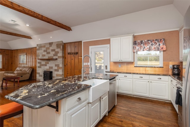 kitchen featuring sink, an island with sink, appliances with stainless steel finishes, a kitchen bar, and white cabinetry