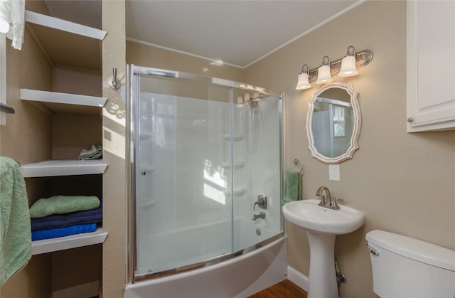 full bathroom featuring combined bath / shower with glass door, sink, crown molding, hardwood / wood-style flooring, and toilet