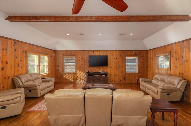 living room with ceiling fan, wooden walls, wood-type flooring, and lofted ceiling