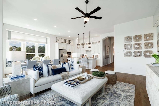 living room featuring ceiling fan and dark wood-type flooring