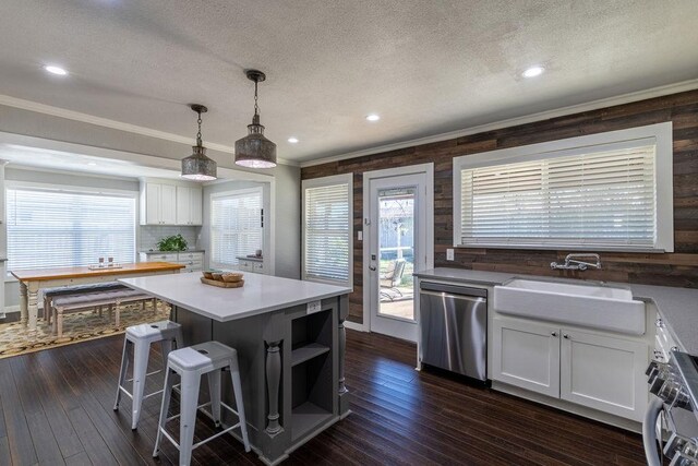 kitchen featuring a center island, white cabinets, stainless steel dishwasher, and sink