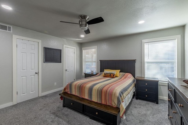 carpeted bedroom with multiple windows, ceiling fan, and a textured ceiling