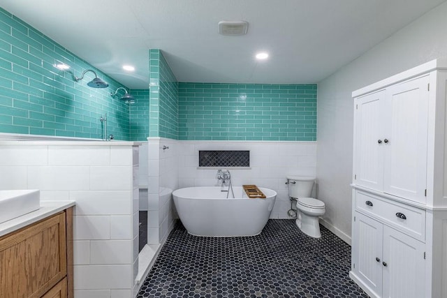 full bathroom featuring tile patterned floors, vanity, separate shower and tub, tile walls, and toilet