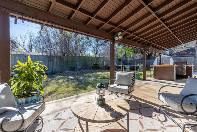 view of patio / terrace featuring a trampoline, area for grilling, and a storage unit