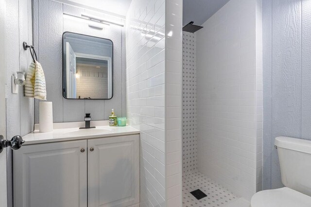 bathroom featuring vanity, toilet, and tiled shower