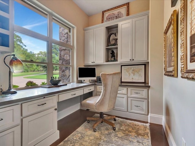 office space featuring baseboards and built in desk