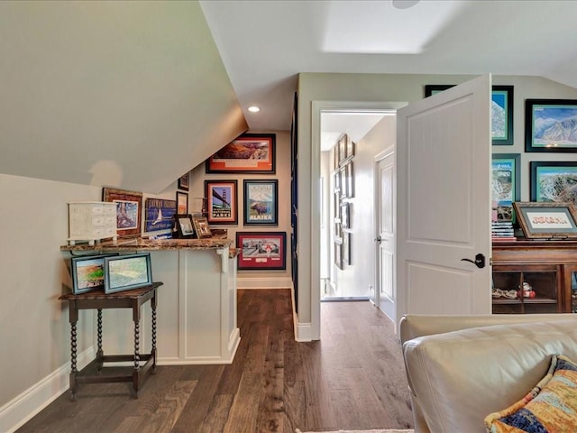 interior space with lofted ceiling, baseboards, and dark wood-type flooring