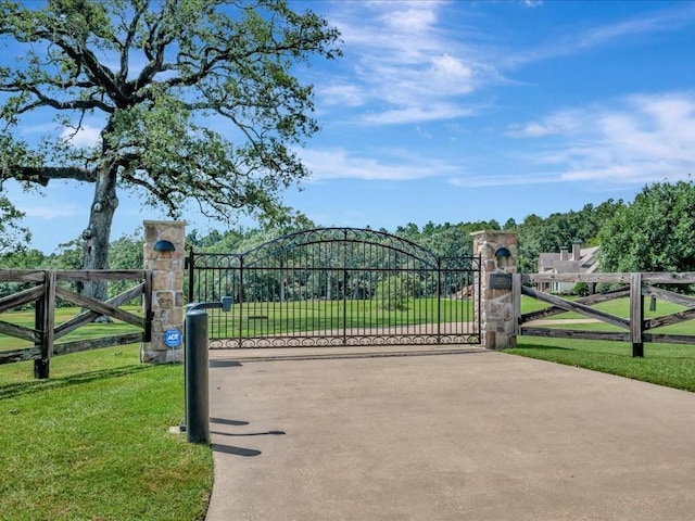 view of gate with a lawn and fence