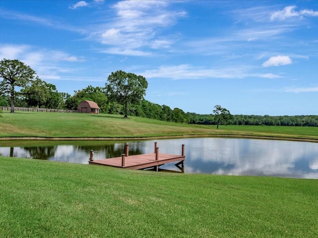 dock area featuring a yard, a water view, and a barn